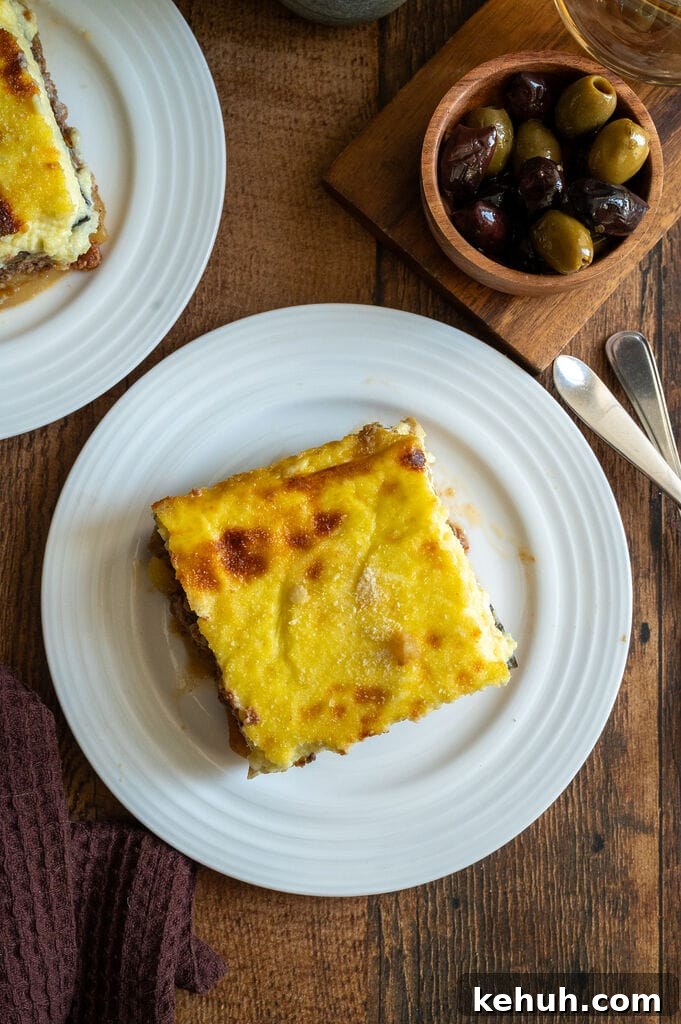 A piece of moussaka on a white plate.