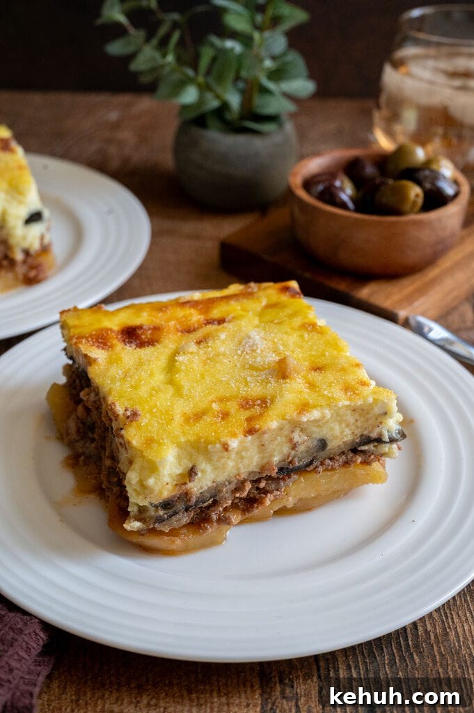 A piece of moussaka on a white plate.
