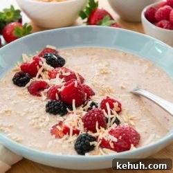 Overnight Oats in a blue Bowl Sprinkled with Fresh Berries and Coconut
