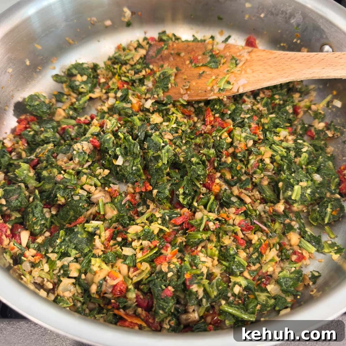Parmesan Spinach-Stuffed Mushrooms: Savory Appetizer Recipe 11 Cooking filling for spinach stuffed mushrooms in a saute pan.