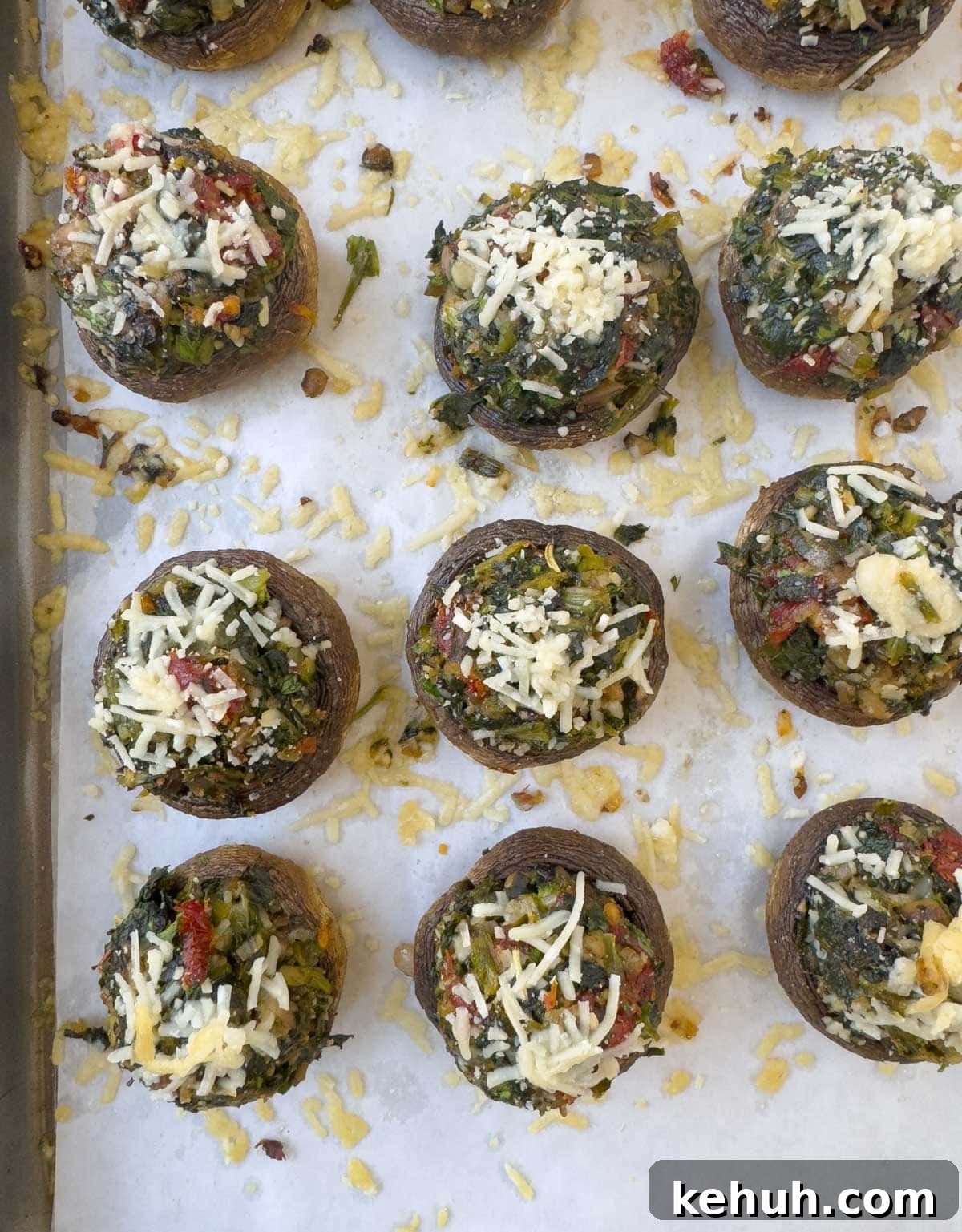 Parmesan Spinach-Stuffed Mushrooms: Savory Appetizer Recipe 14 Baked stuffed mushrooms topped with parmesan cheese on a baking tray.