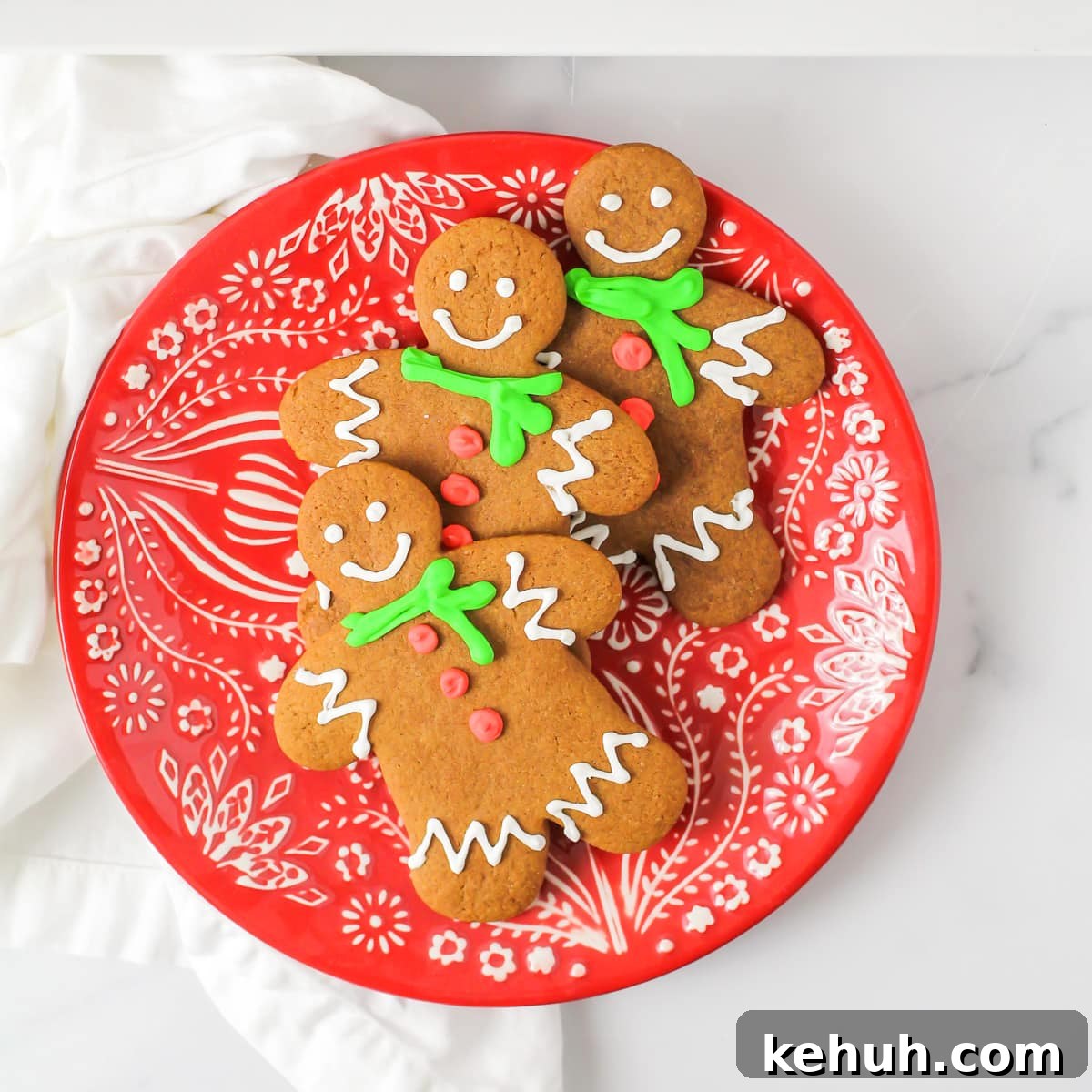 The Best Gingerbread cookie recipe - decorated and stacked on a Christmas plate.