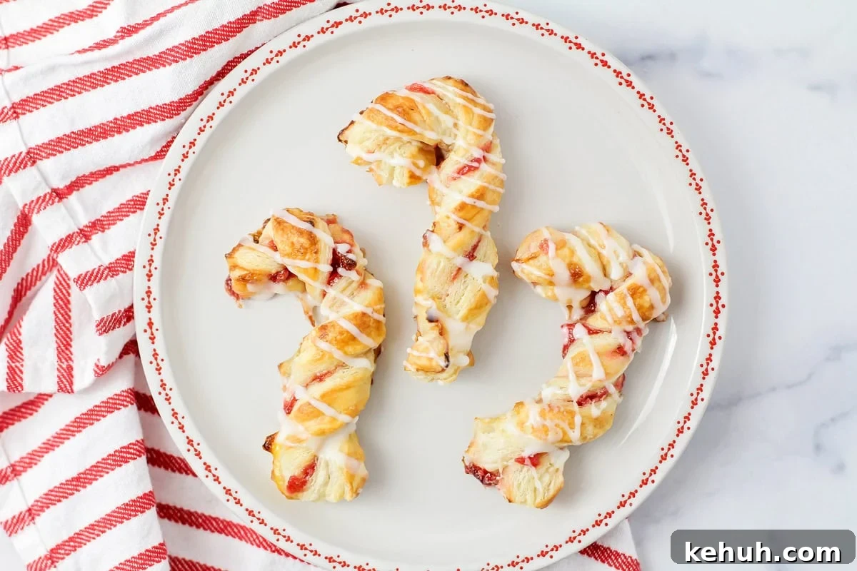 Puff pastry candy canes on a red and white plate.