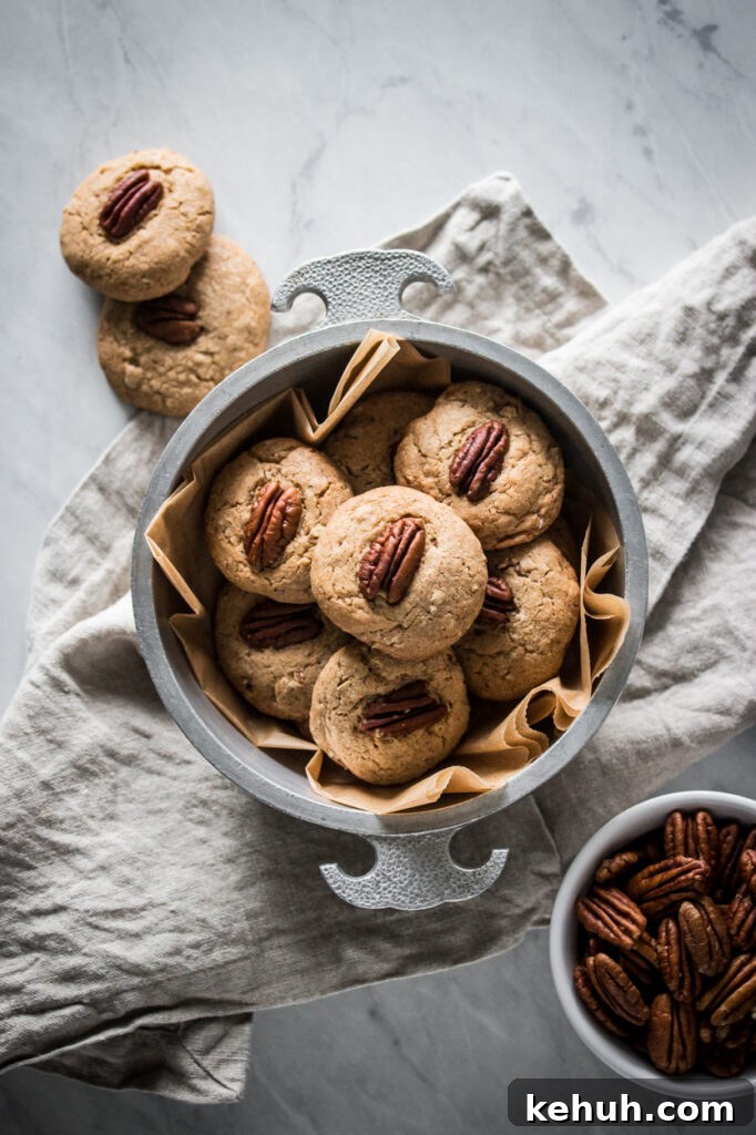 Gluten-Free Butter Pecan Cookie Recipe: Crisp, Nutty Cookies 2 a silver bowl of gluten free butter pecan cookies next to a bowl of pecans on a marble surface