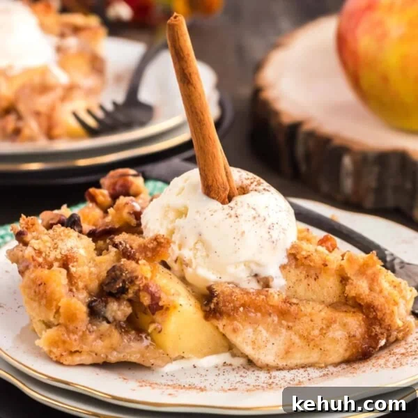 Dutch apple pie on a plate with ice cream and a cinnamon stick.