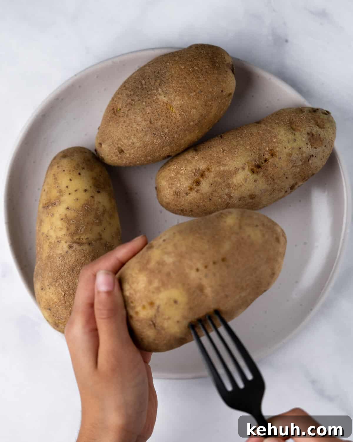 Crispy Air Fryer Potato Skins Filled with Cheesy Bacon 4 Poking holes into potato with fork.