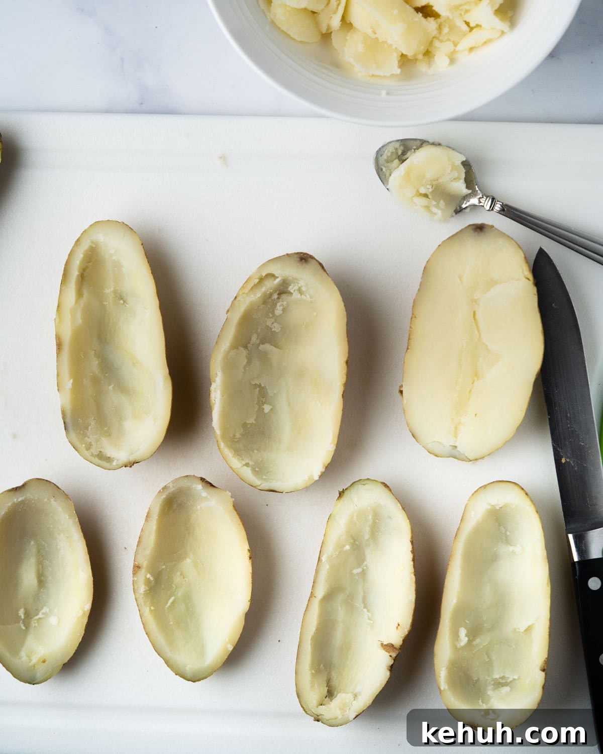Crispy Air Fryer Potato Skins Filled with Cheesy Bacon 5 scooping out middle of potato with spoon.