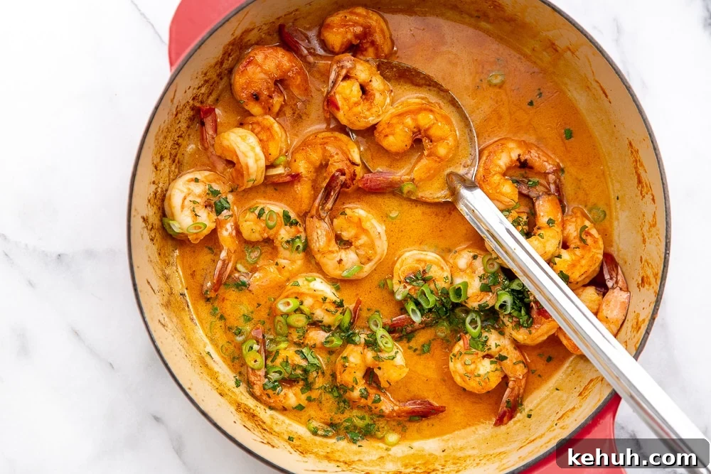 Coconut Sriracha Shrimp with Garlicky Kale Bowl 3 Shrimp in coconut sriracha sauce in skillet, with serving spoon