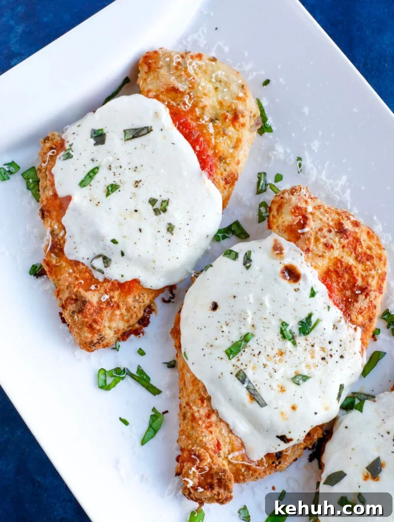 Baked Chicken Parmesan Overhead shot of Baked chicken parm with cheese and basil topping