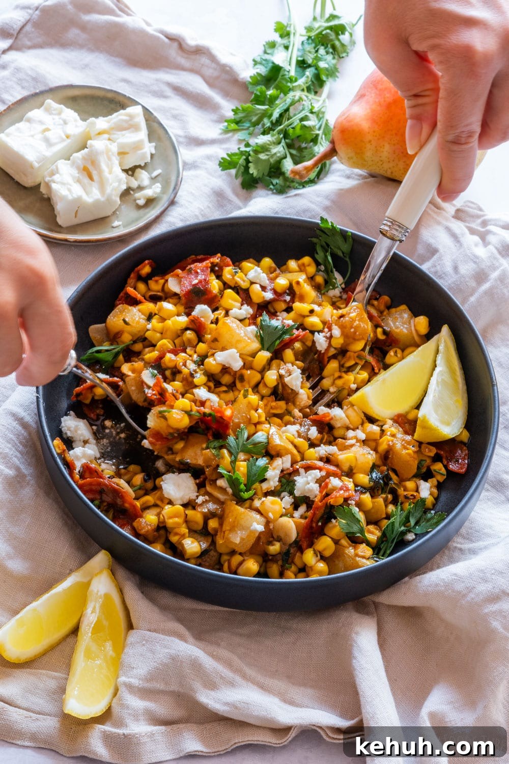 Grilled Corn Salad with Cherry Tomatoes and Lime Vinaigrette 8 Serving corn salad with two spoons.