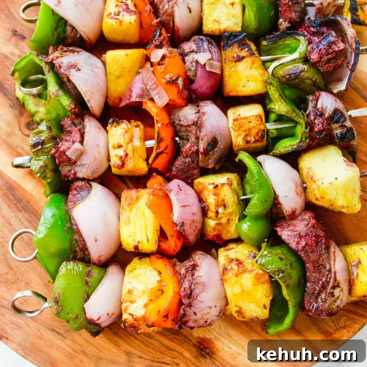 A wooden platter filled with Shish Kabob grilled skewers.
