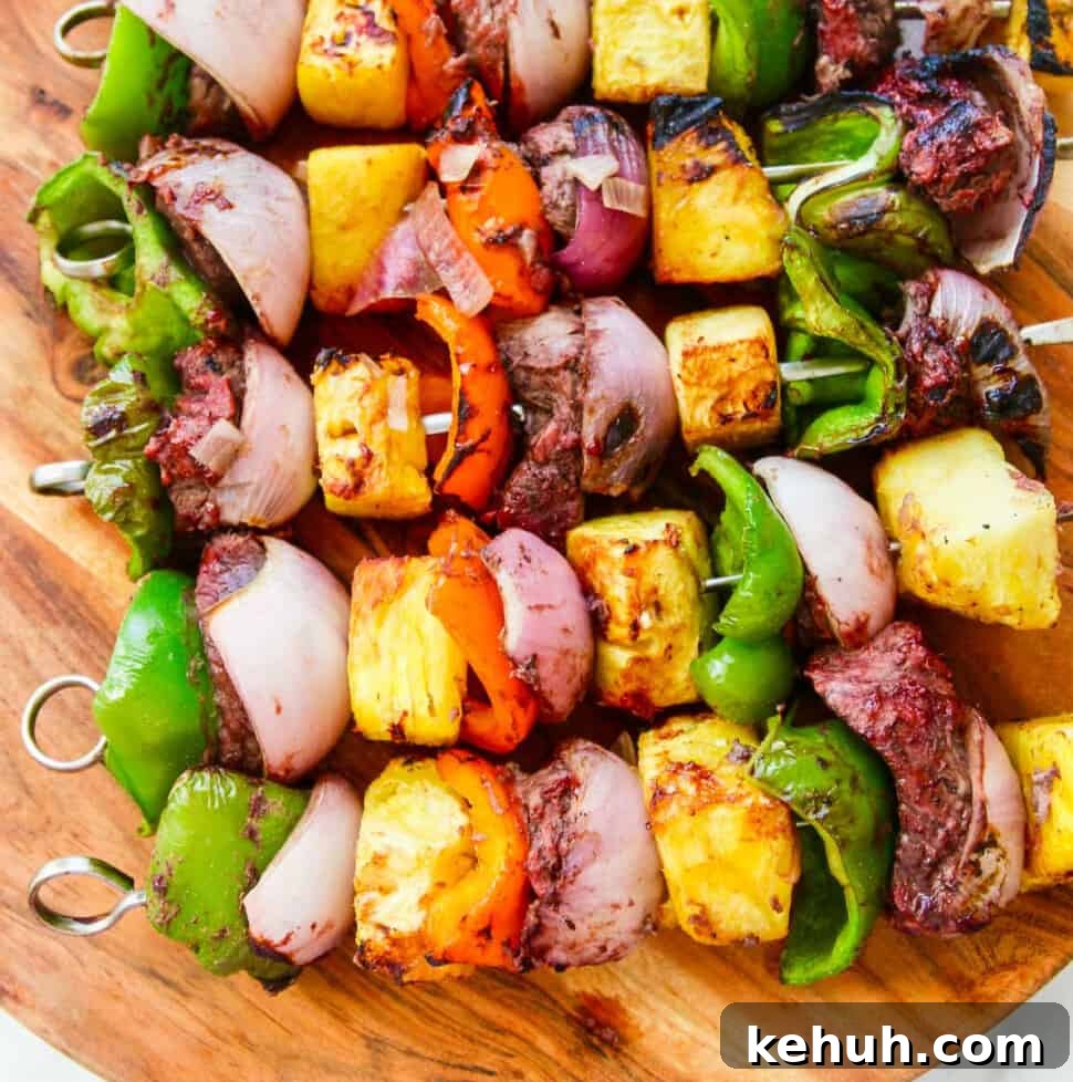 A wooden platter filled with Shish Kabob grilled skewers.