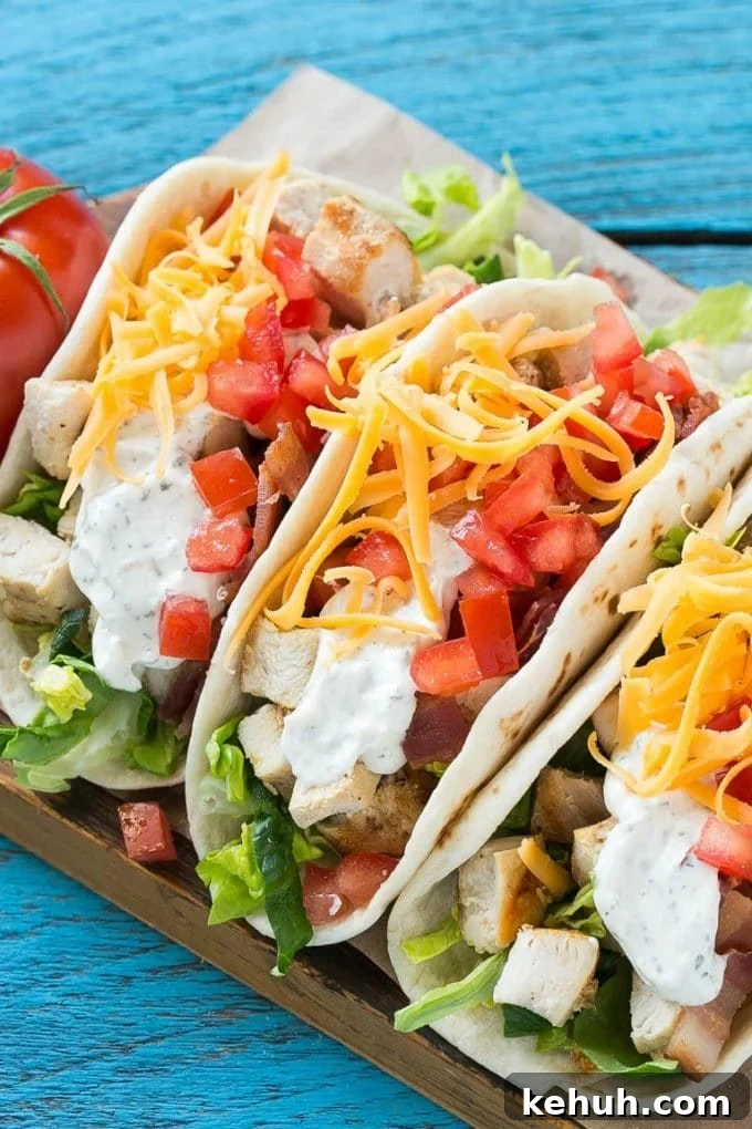 Chicken tacos filled with lettuce, tomatoes, ranch and bacon.