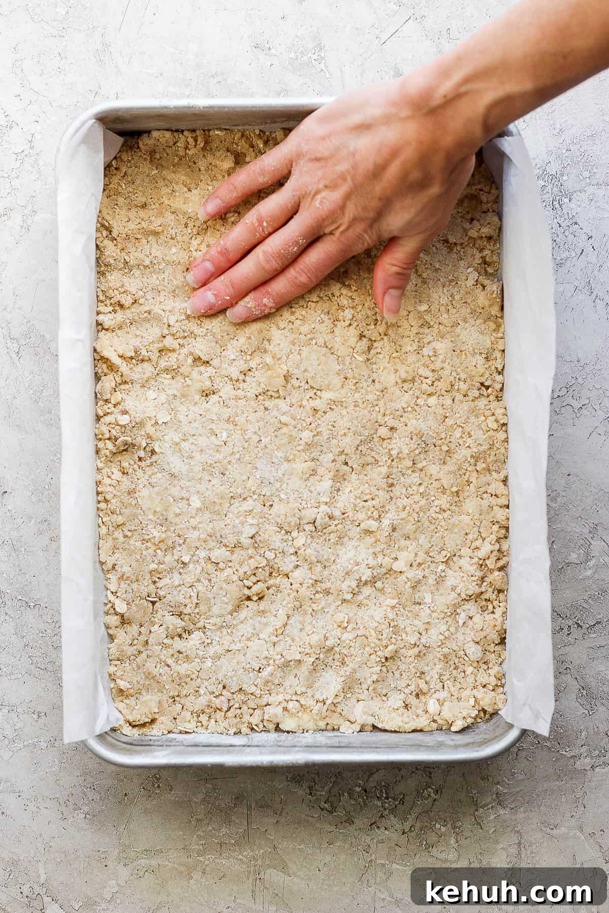 Half of the flour and butter mixture pressed into a parchment lined 9x13 baking pan.