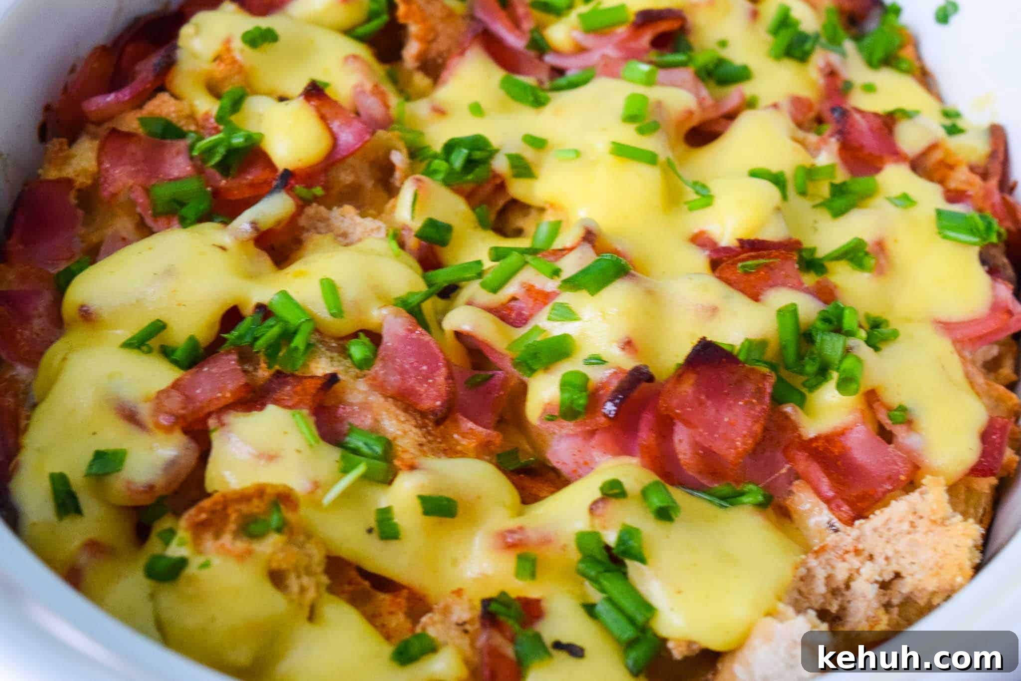 Overnight Eggs Benedict Casserole topped with chives close up view 