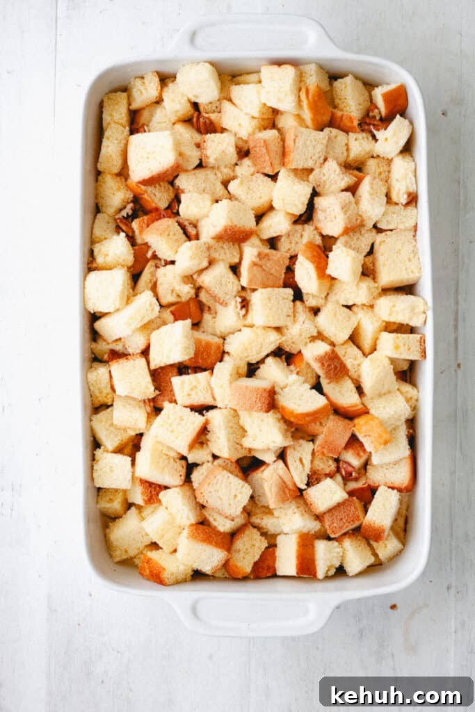 Brioche French Toast Casserole Recipe for Brunch and Holidays 8 An uncooked brioche french toast casserole in a white baking dish.