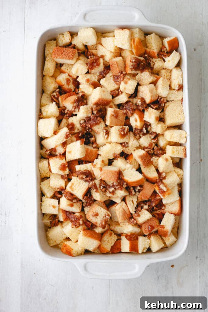 Brioche French Toast Casserole Recipe for Brunch and Holidays 9 A brioche French toast casserole getting assembled with a brown sugar and pecan topping.