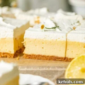 Tangy Lemon Bars with Crisp Graham Cracker Crust 9 creamy lemon bars with graham cracker crust on a piece of parchment paper topped with edible flower and lemon whipped cream.