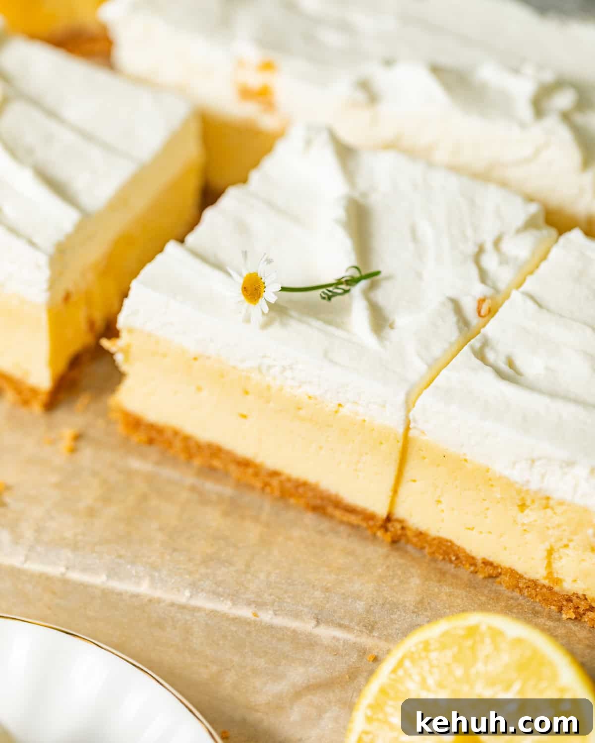 Tangy Lemon Bars with Crisp Graham Cracker Crust 8 lemon bars on parchment paper cut into slices.