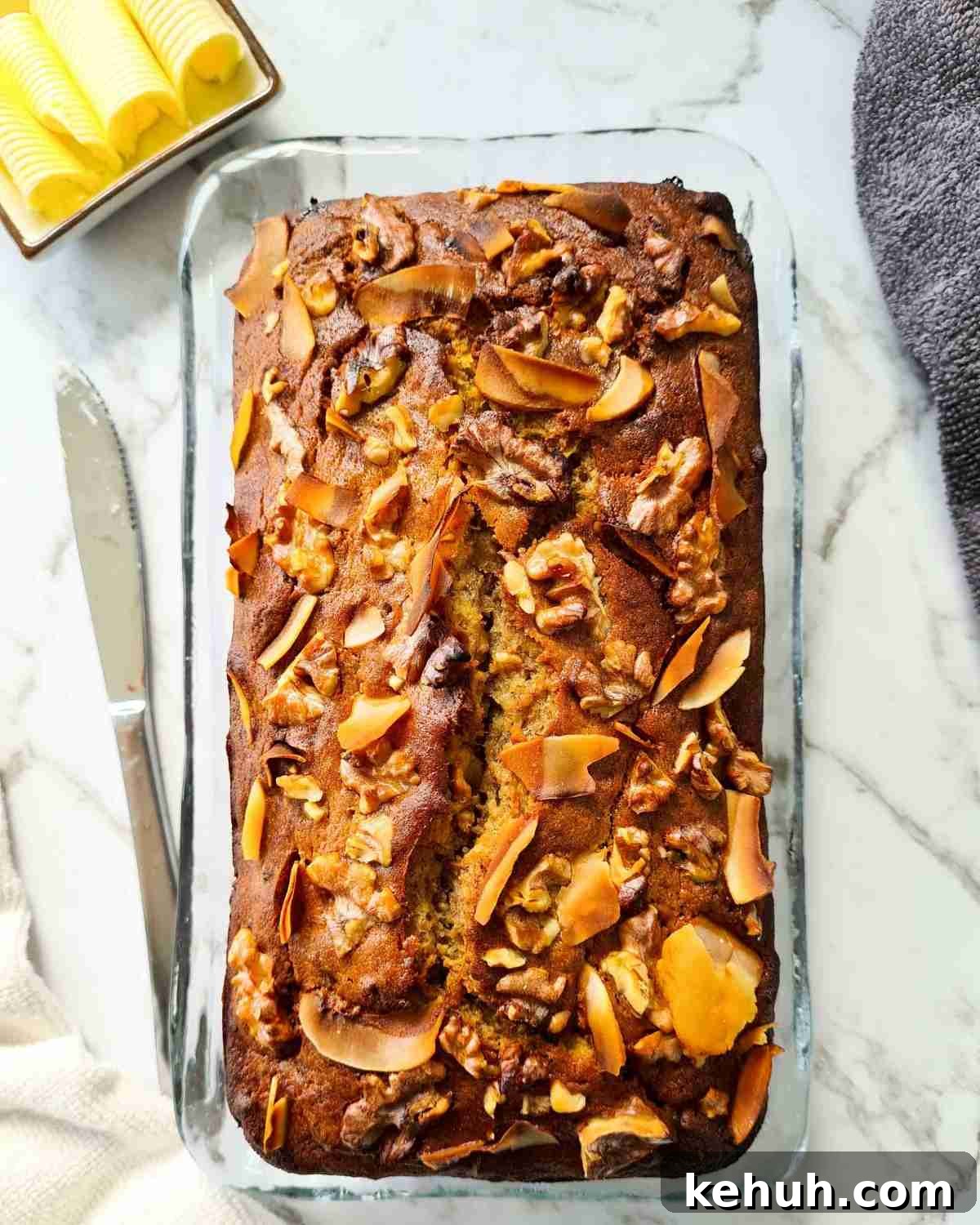 Freshly baked banana bread on top of a wooden board, unsliced
