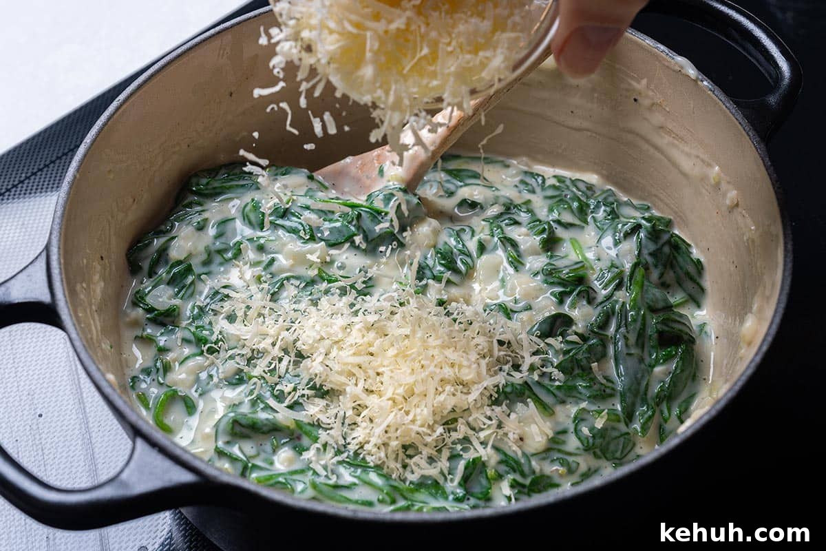 Creamy Parmesan Spinach Recipe — Quick Sautéed Side Dish 7 easy creamy spinach in a pot having cheese sprinkles over it