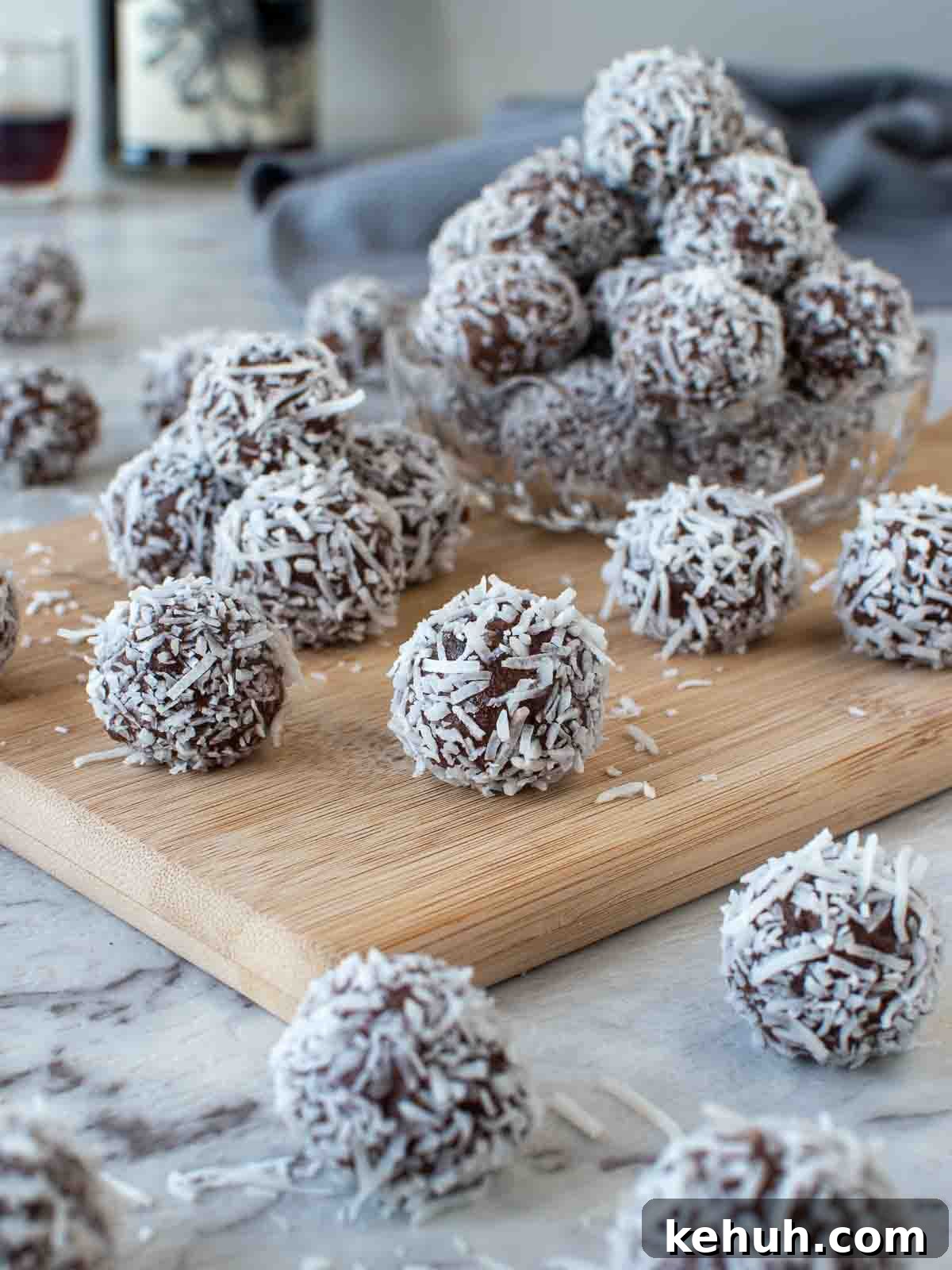 Several of my rum balls recipe piled in a wooden board.