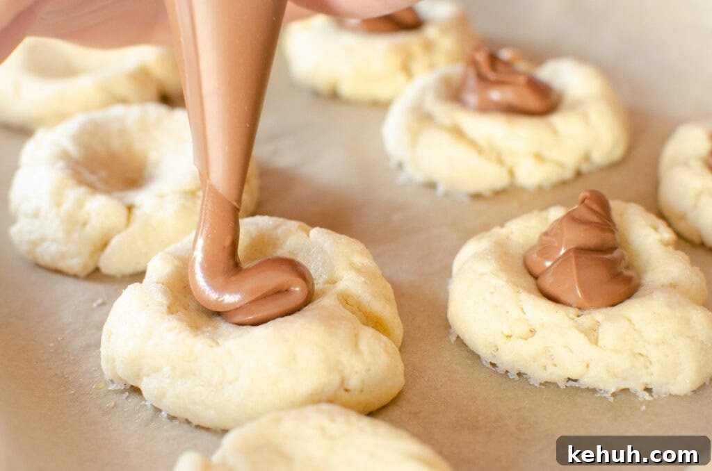 Thumbprint Cookies with Jam, Curd, or Chocolate Filling 16 creating chocolate thumbprint cookies using chocolate spread in a piping bag.