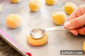 Thumbprint Cookies with Jam, Curd, or Chocolate Filling 8 Making the hole in the cookie with a teaspoon on a baking tray