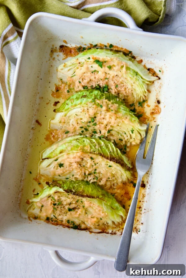 Baked Cabbage with Garlic and Parmesan in white baking dish with serving fork.
