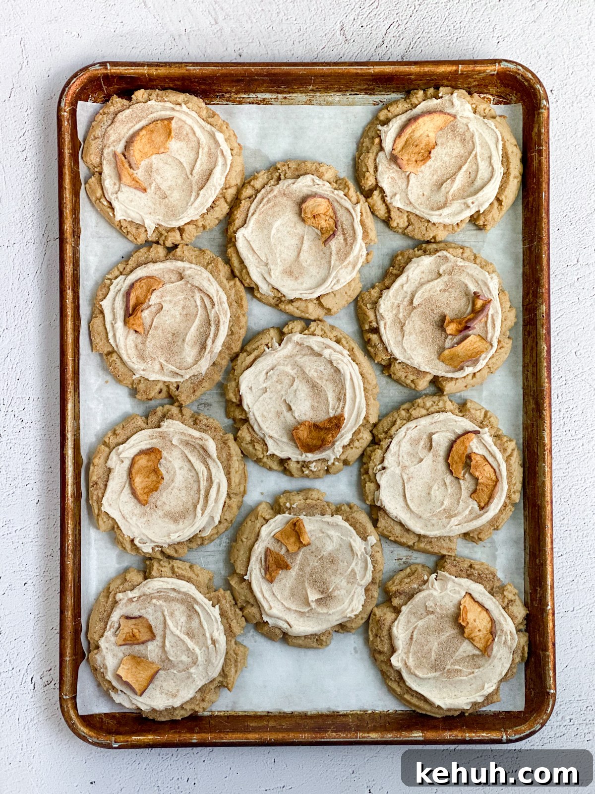 Soft Apple Cider Cookies Recipe with Warm Spices 3 all the apple cider cookies topped with dried apples lined up on a cookie sheet.