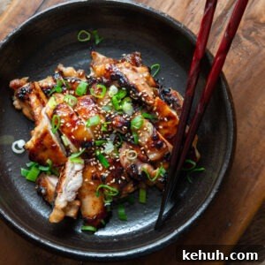 A plate of miso chicken thighs with chopsticks.
