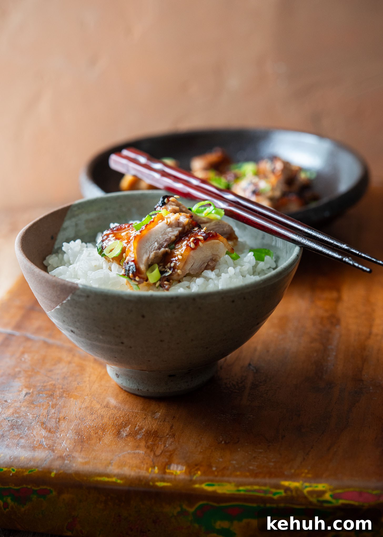 Bowl of rice topped with juicy miso chicken thighs and green onion