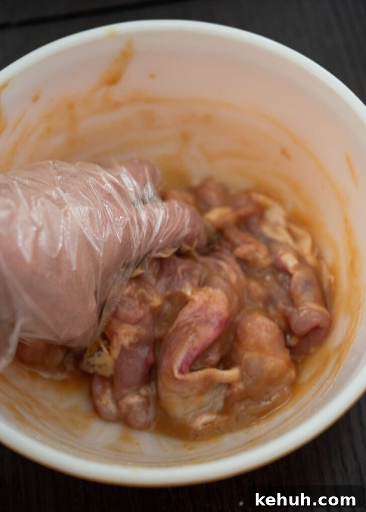 Coating chicken thighs evenly with miso marinade