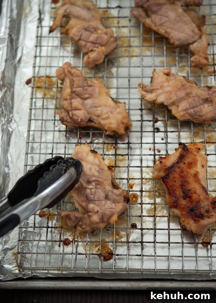 Flipping broiled miso chicken thighs for even cooking