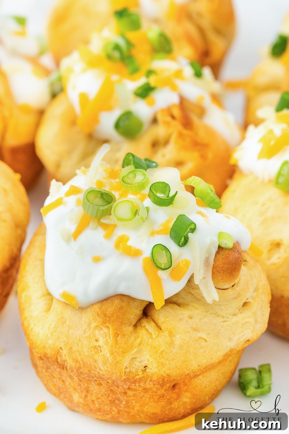 Spicy Chili-Stuffed Dinner Rolls: Savory Bite-Sized Appetizers 3 Chili stuffed rolls! Buttery biscuits surrounding chili and cheese, topped with sour cream and green onions.