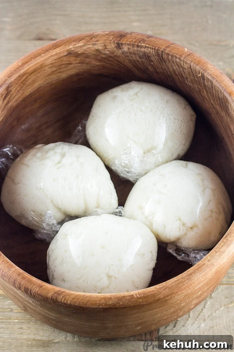 Wrapped corn fufu in a wooden bowl.