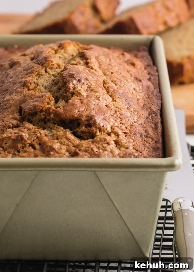banana bread cooling in a loaf pan on a wire rack
