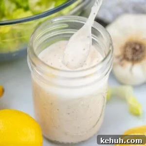 Classic Homemade Caesar Dressing Recipe — Creamy, Tangy & Authentic 2 Jar of homemade Caesar Salad dressing with spoon next to lemons.