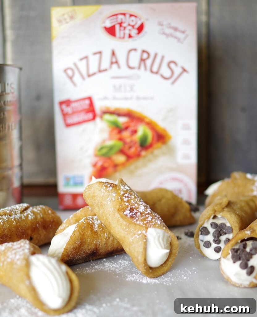 a side view of a top down view of cannolis dusted with powdered sugar in front of a pizza crust mix box