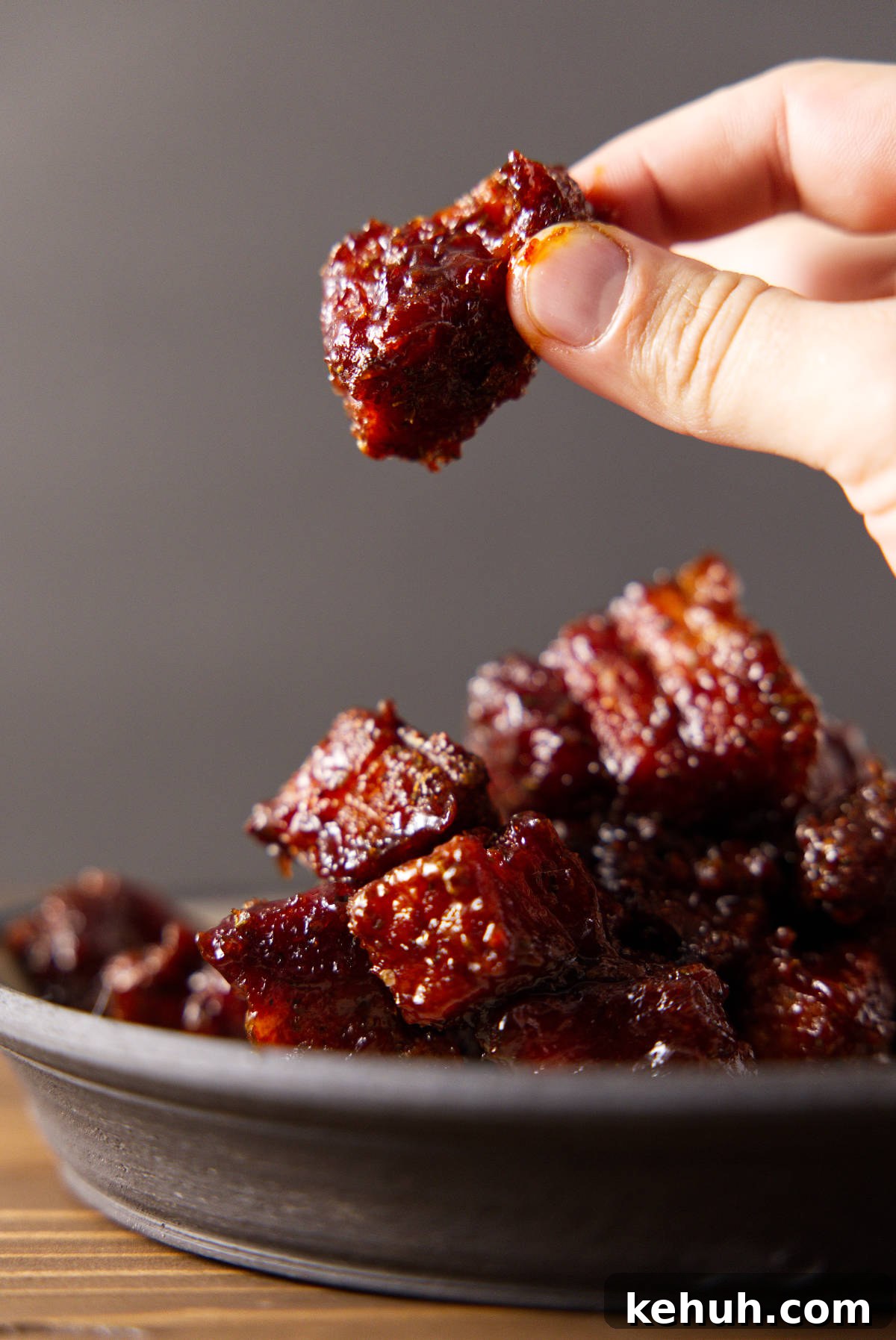Holding up a chunk of burnt ends.