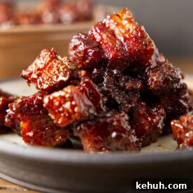 Close up of pork burnt ends stacked on a plate.