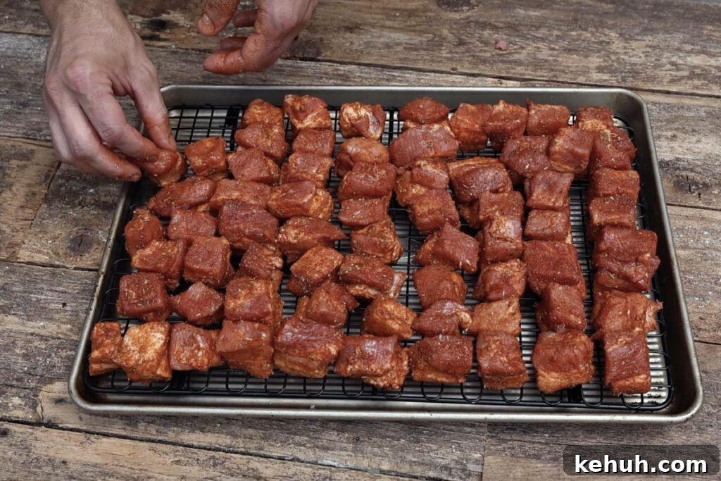 Arranging cubes of pork belly on a wire rack.
