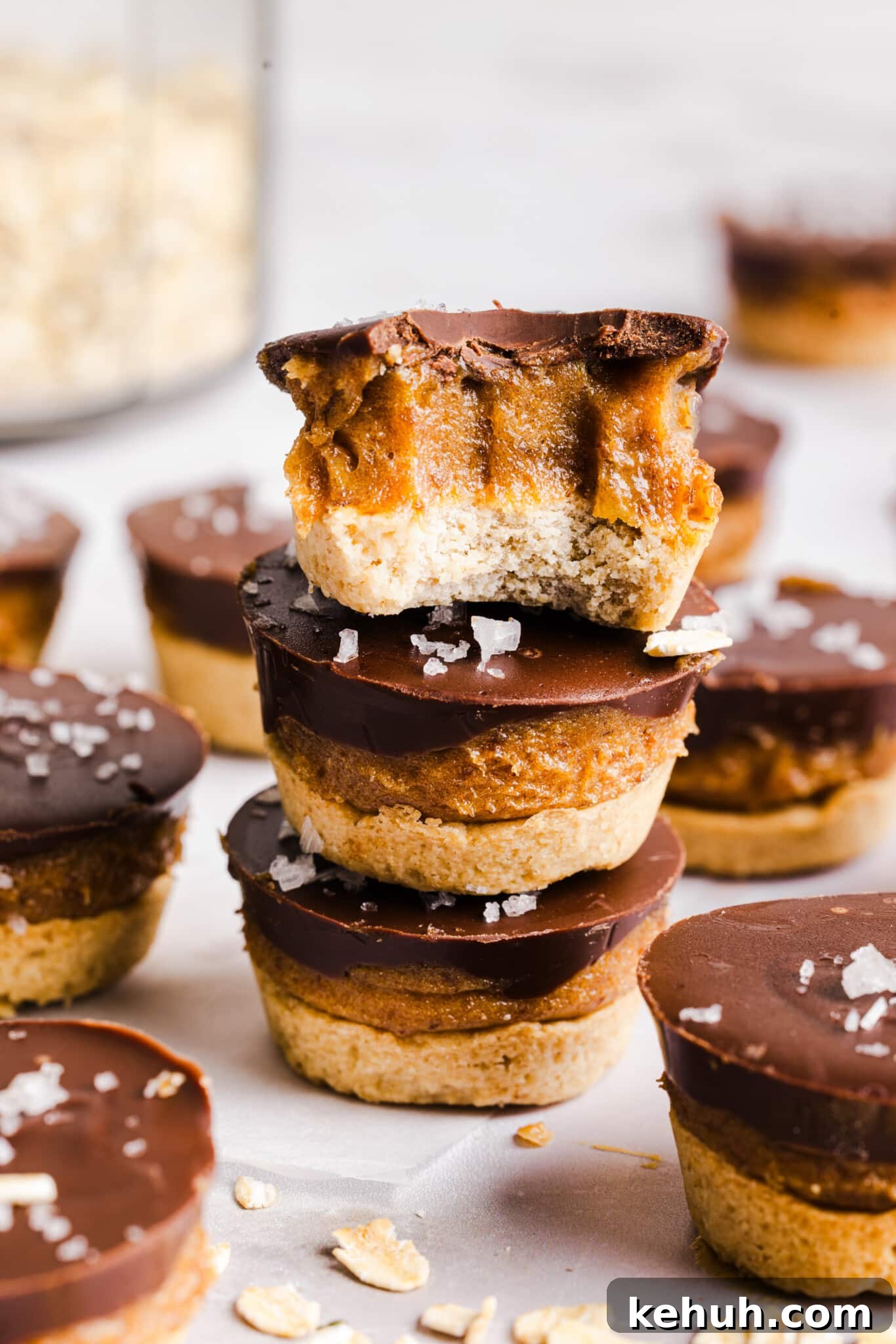 Three Twix bites stacked on a countertop. A bite is taken out of the top Twix bite.