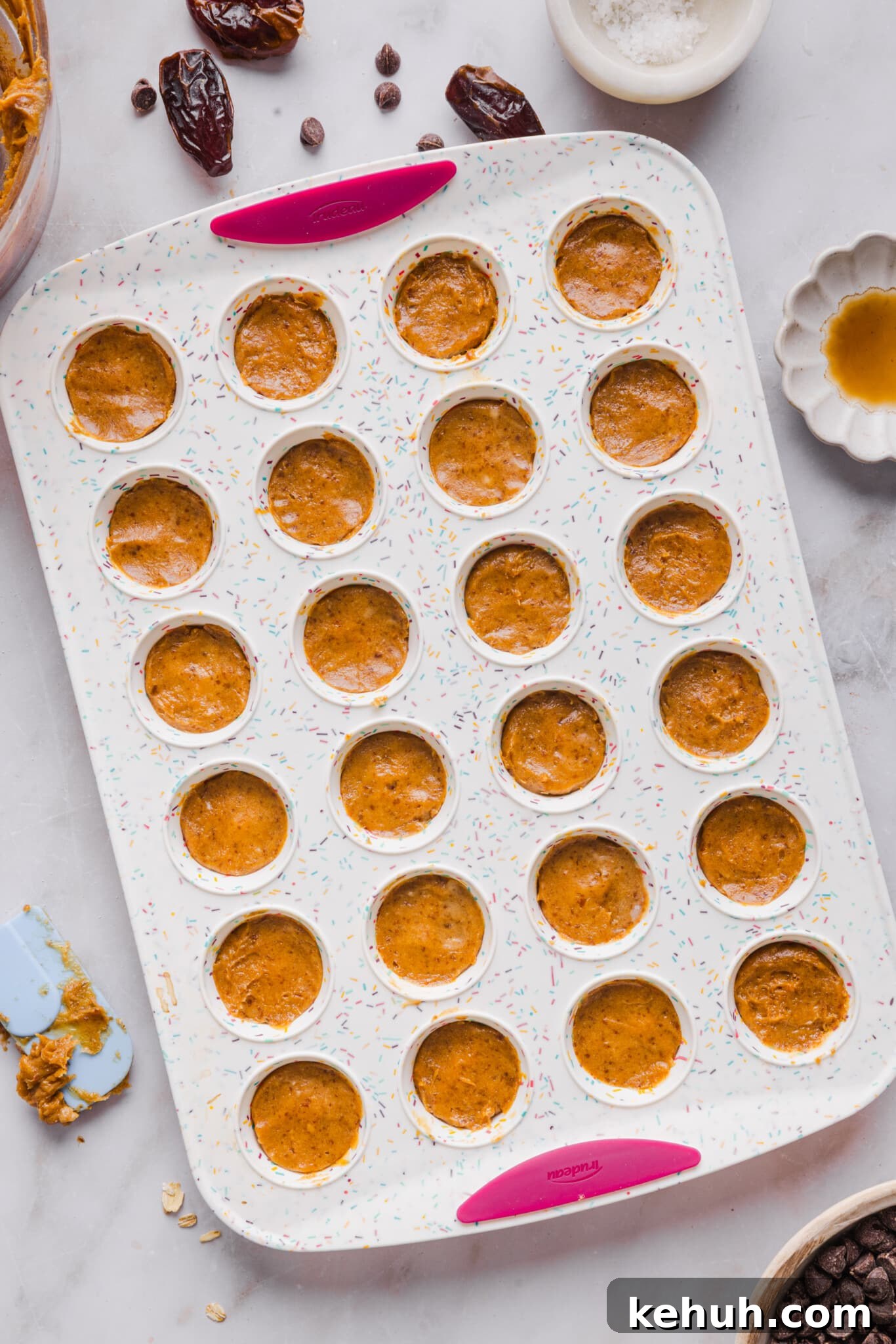 Date caramel layered with chocolate in a mini muffin silicone pan.