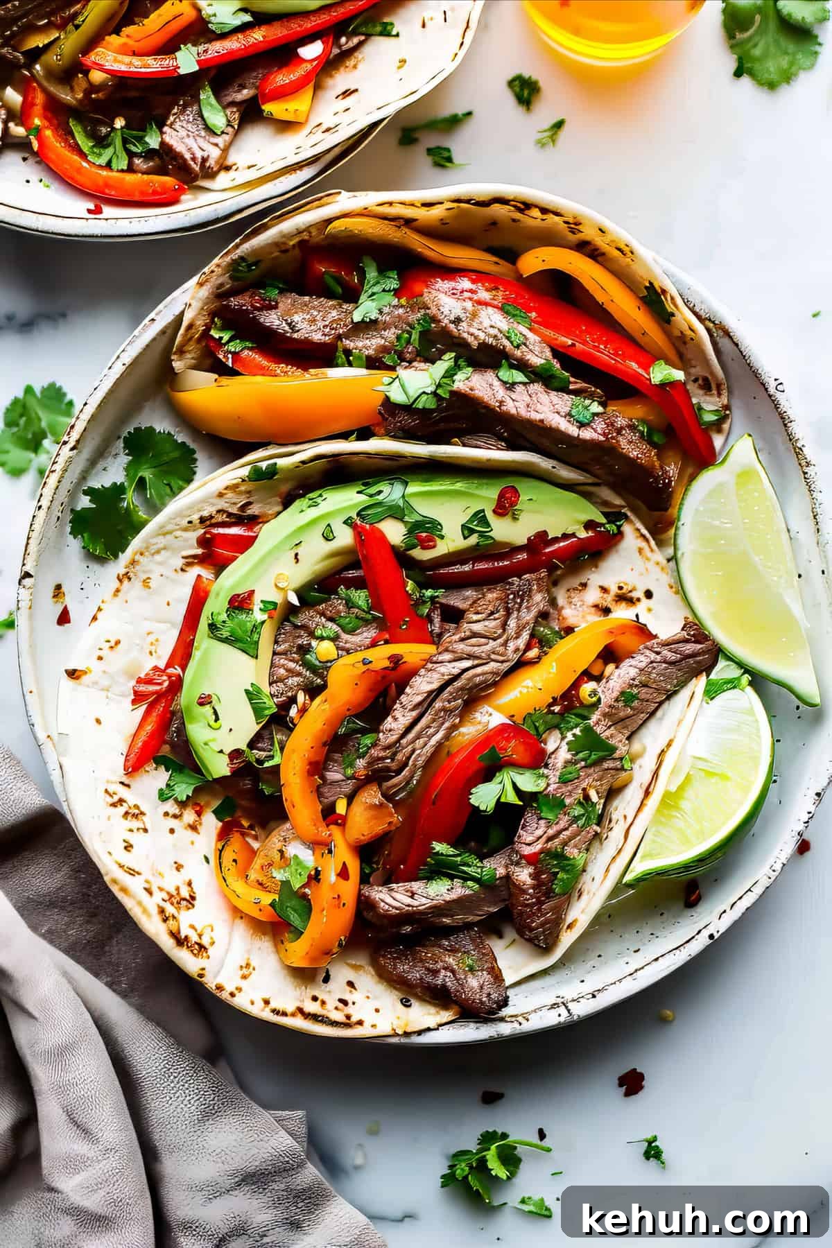 Flank steak fajitas with herbs and avocado in tortillas.