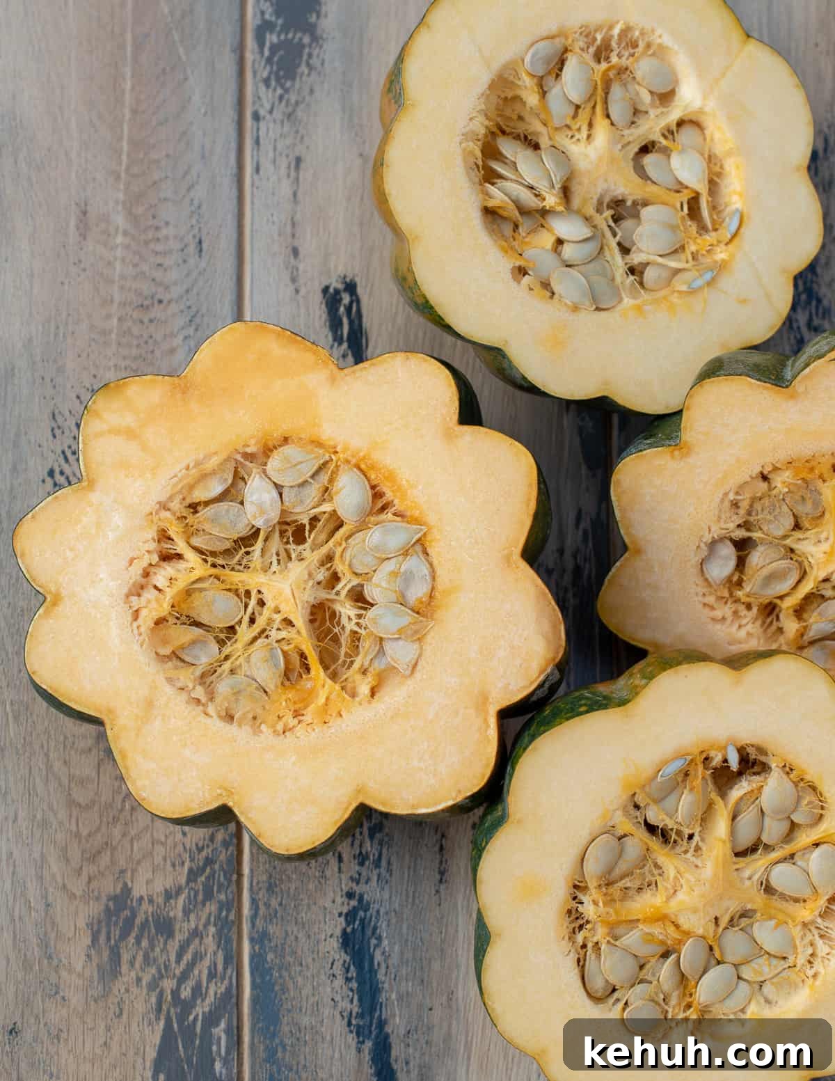 A top dpwm shot of acorn squash that have been sliced in half to reveal the seeds inside.
