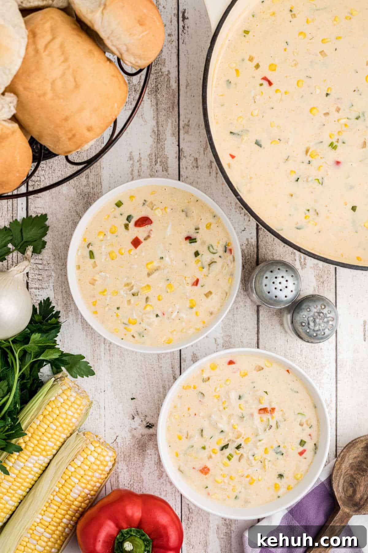 dished out corn and crab bisque, 2 bowls with some bread in the