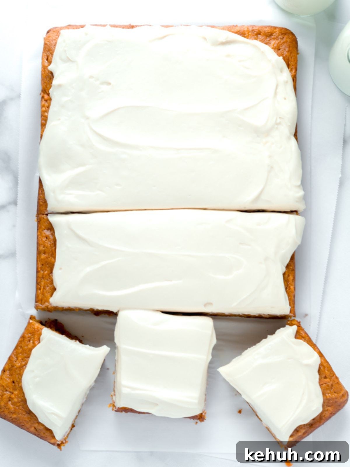 Moist Pumpkin and Carrot Layer Cake Recipe 10 A pumpkin carrot sheet cake with brown sugar cream cheese frosting cut into slices.