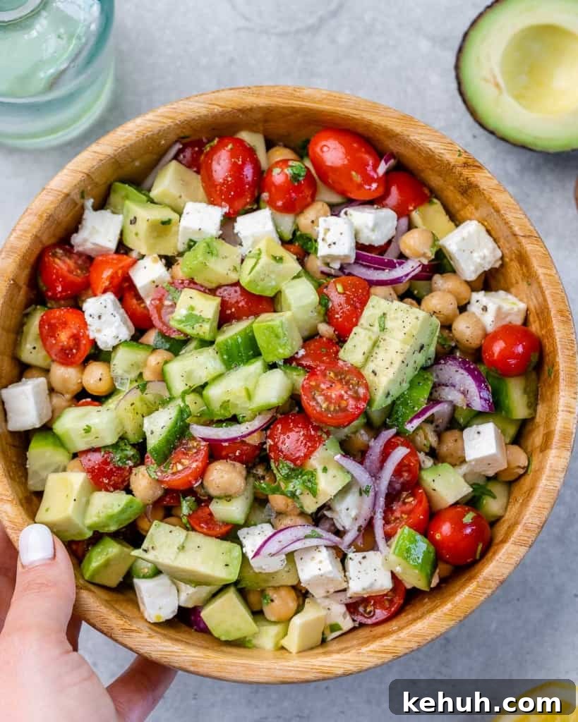 Mediterranean Chickpea and Feta Salad Recipe 2 hand holding brown bowl of greek chickpea feta salad
