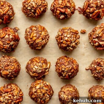 Authentic Kentucky Bourbon Balls Recipe: No-Bake Holiday Treat 5 Parchment lined sheet pan with rows of bourbon pecan truffle balls.